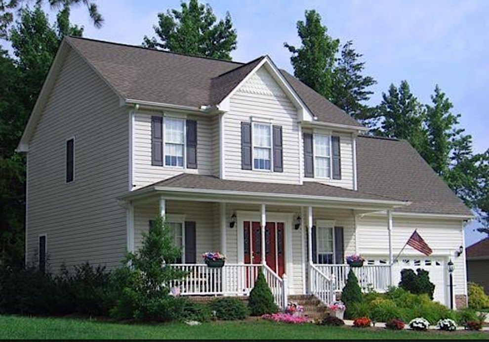 Cette image montre une grande façade de maison beige traditionnelle en bardage à clin à un étage avec un revêtement en vinyle, un toit à deux pans, un toit en shingle et un toit gris.