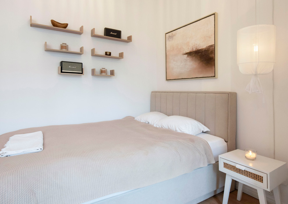 Kleines, Offenes Modernes Wohnzimmer mit weißer Wandfarbe, hellem Holzboden und braunem Boden in München