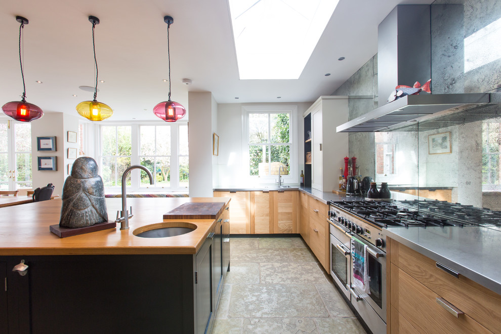 Photo of a large contemporary u-shaped open plan kitchen in Surrey with an integrated sink, shaker cabinets, black cabinets, stainless steel benchtops, metallic splashback, glass tile splashback, stainless steel appliances, terrazzo floors and with island.