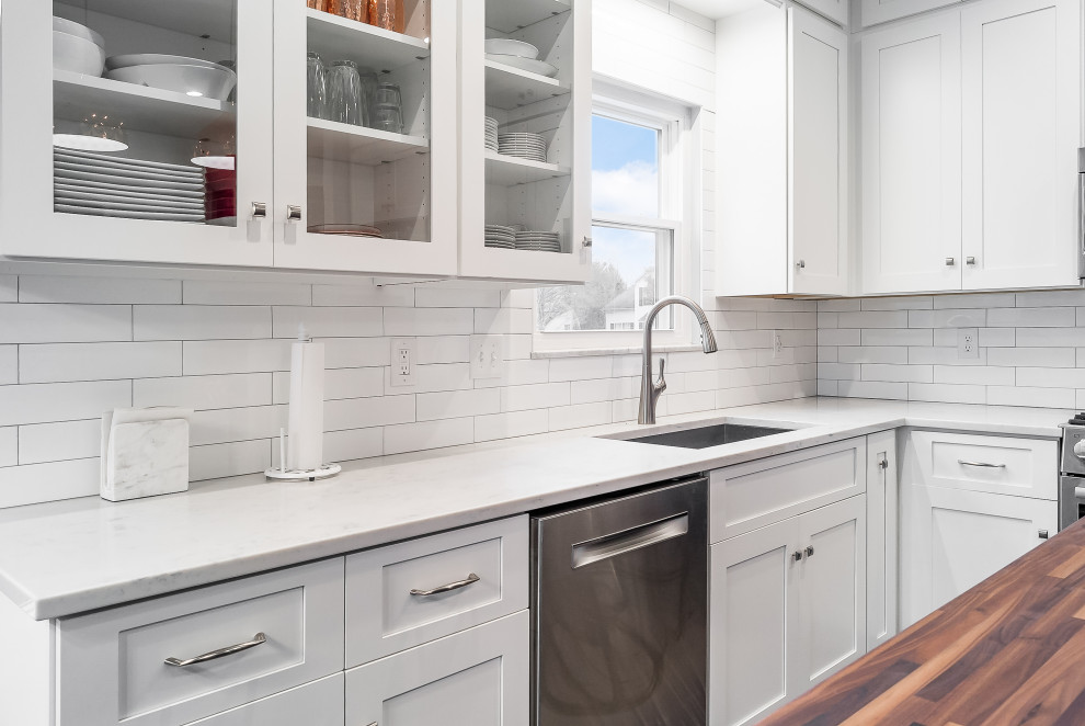 Inspiration for a mid-sized transitional l-shaped eat-in kitchen remodel in Columbus with shaker cabinets, quartz countertops, white backsplash, subway tile backsplash and an island