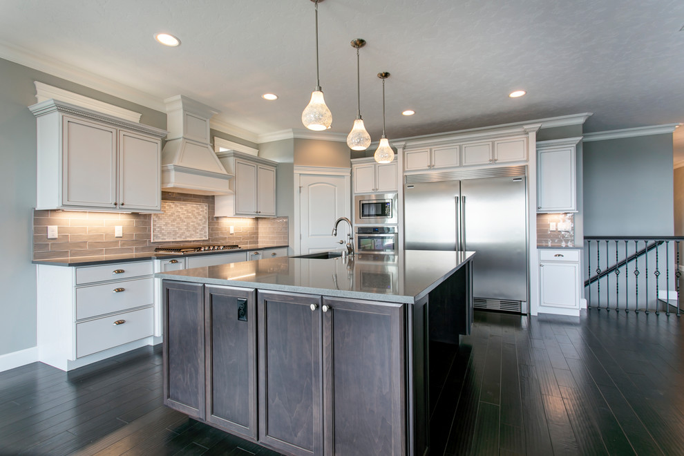 Inspiration for a mid-sized transitional l-shaped dark wood floor open concept kitchen remodel in Seattle with an undermount sink, shaker cabinets, white cabinets, quartz countertops, gray backsplash, glass tile backsplash, stainless steel appliances and an island