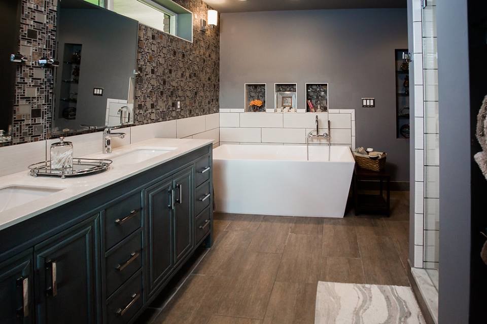 Photo of a large contemporary master bathroom in Detroit with raised-panel cabinets, green cabinets, a freestanding tub, an alcove shower, white tile, porcelain tile, grey walls, porcelain floors, an undermount sink, engineered quartz benchtops, brown floor and a hinged shower door.