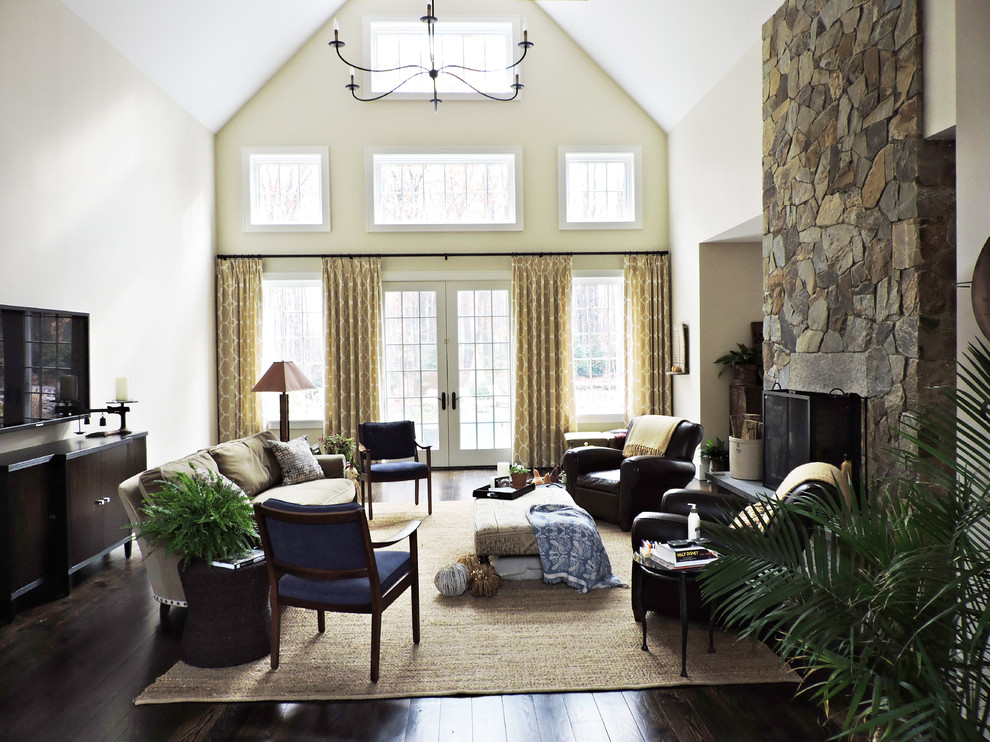 Large country formal enclosed living room in Other with beige walls, dark hardwood floors, a two-sided fireplace, a stone fireplace surround, a wall-mounted tv and brown floor.