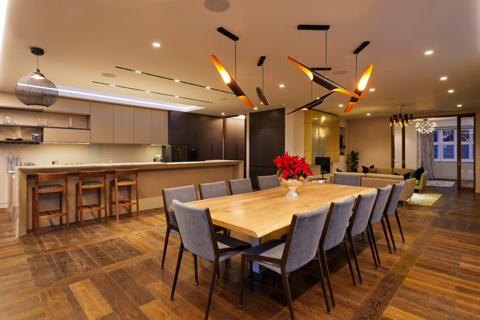 This is an example of an open plan dining in London with white walls, dark hardwood floors and brown floor.