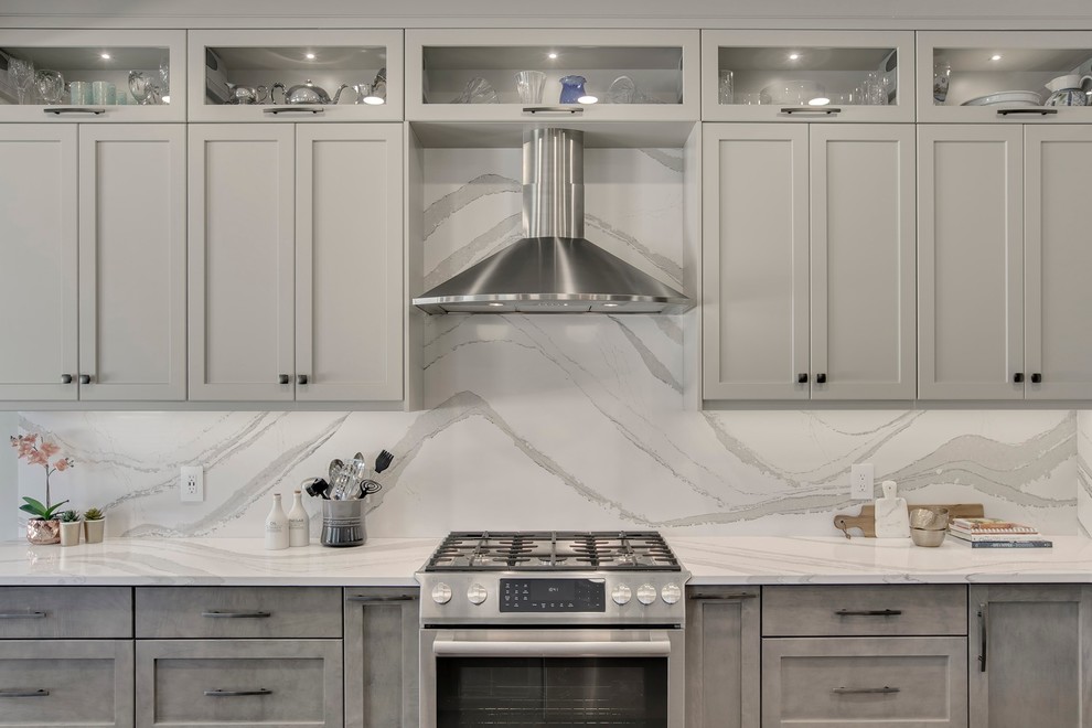 Example of a large transitional u-shaped dark wood floor and brown floor eat-in kitchen design in Calgary with an undermount sink, recessed-panel cabinets, gray cabinets, quartzite countertops, white backsplash, stone slab backsplash, stainless steel appliances, an island and white countertops