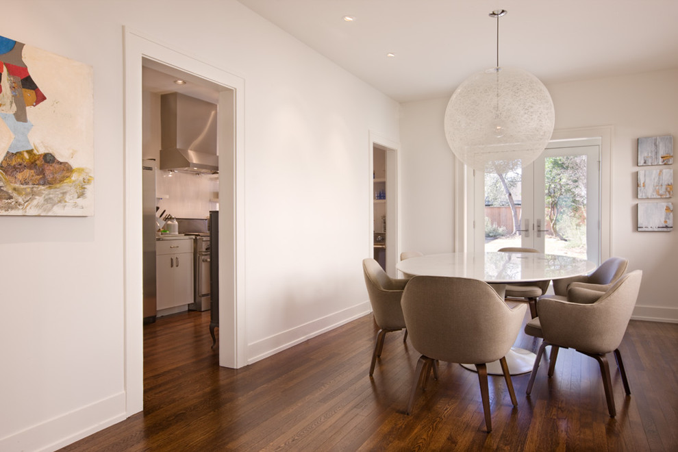 Photo of a contemporary dining room in Austin with white walls and dark hardwood floors.