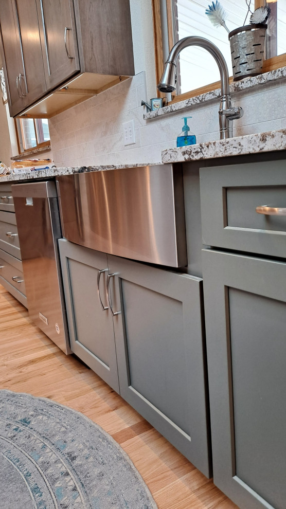 Mid-sized transitional galley light wood floor kitchen photo in Denver with shaker cabinets, porcelain backsplash and stainless steel appliances