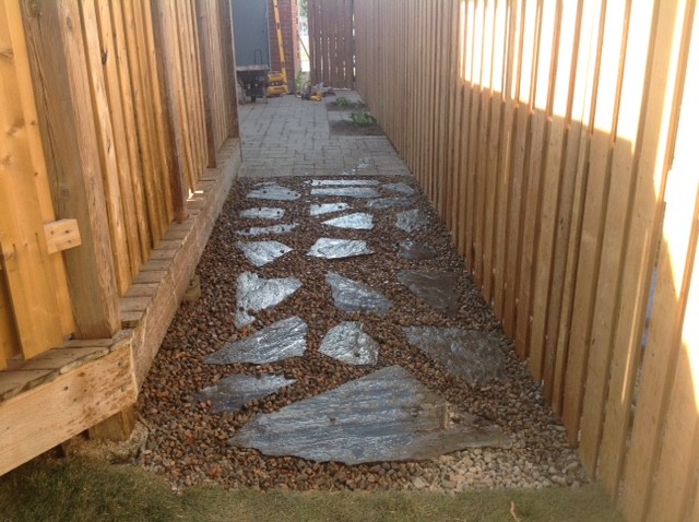 Photo of a mid-sized rustic partial sun front yard concrete paver driveway in Toronto for summer.