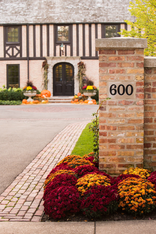 Large traditional front yard full sun driveway in Chicago with brick pavers for fall.