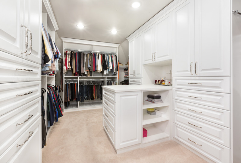 Design ideas for a large traditional gender-neutral walk-in wardrobe in Chicago with raised-panel cabinets, white cabinets and carpet.