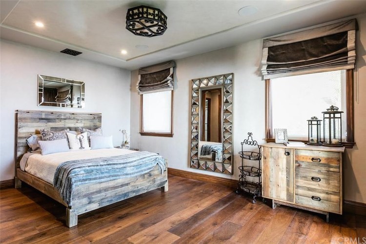 Inspiration for a mid-sized rustic guest dark wood floor and brown floor bedroom remodel in Phoenix with gray walls and no fireplace