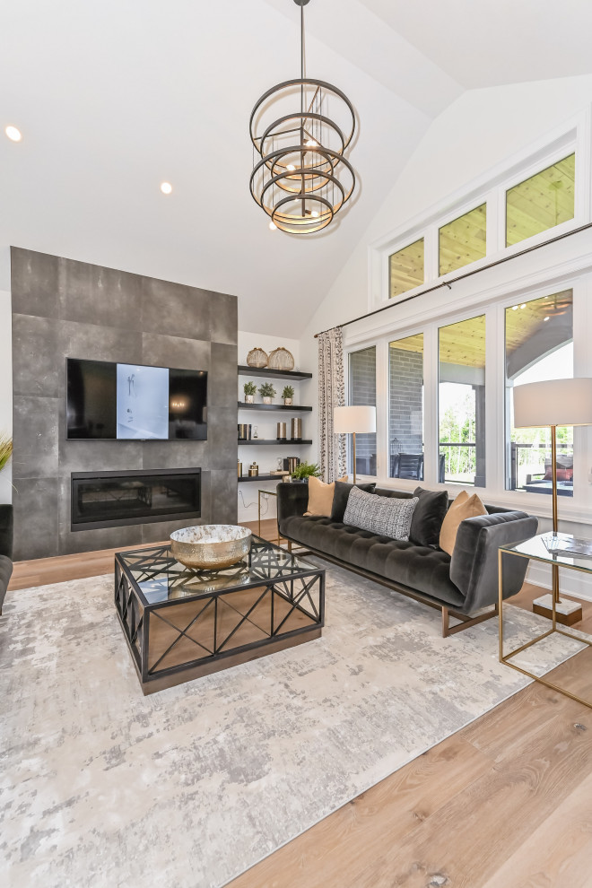 Photo of a large contemporary living room in Toronto with a two-sided fireplace, a tile fireplace surround and a wall-mounted tv.