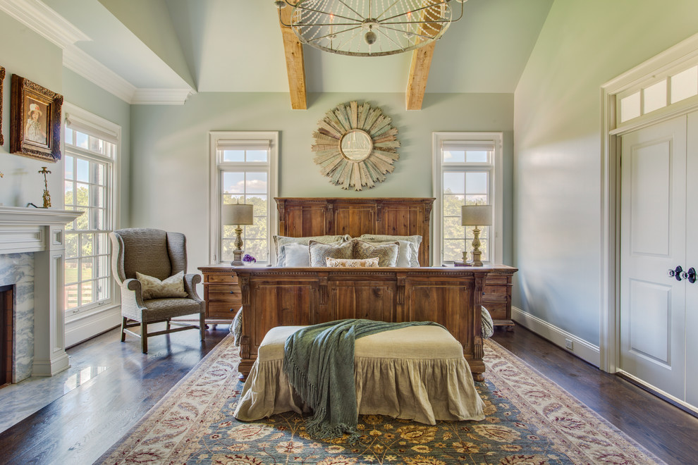 Country bedroom in Nashville with green walls, dark hardwood floors, a standard fireplace and a stone fireplace surround.