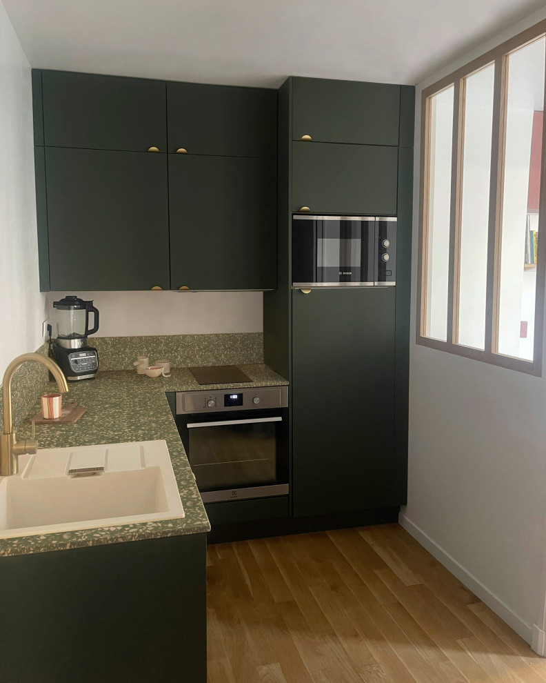 Inspiration for a mid-sized modern l-shaped separate kitchen in Paris with a single-bowl sink, flat-panel cabinets, green cabinets, terrazzo benchtops, green splashback, light hardwood floors and green benchtop.