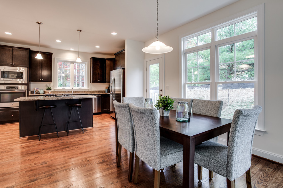Example of a mid-sized transitional l-shaped medium tone wood floor eat-in kitchen design in DC Metro with an undermount sink, shaker cabinets, dark wood cabinets, granite countertops, stainless steel appliances and an island