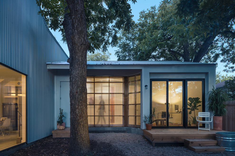 На фото: маленький, двухэтажный частный загородный дом в современном стиле с облицовкой из металла, двускатной крышей и металлической крышей для на участке и в саду с