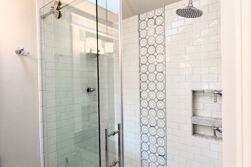 This is an example of a mid-sized transitional master bathroom in Portland with raised-panel cabinets, white cabinets, an alcove shower, white tile, subway tile, grey walls, porcelain floors, an undermount sink, solid surface benchtops, grey floor and a sliding shower screen.