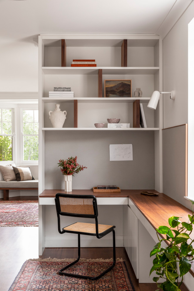 Idéer för ett modernt arbetsrum, med grå väggar, mörkt trägolv, ett inbyggt skrivbord och brunt golv