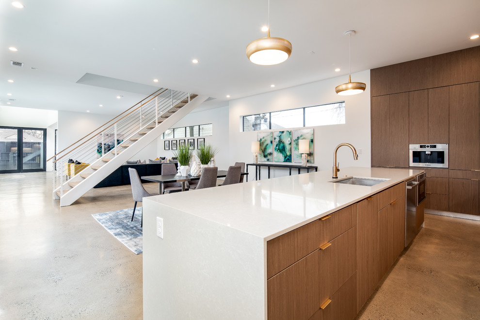 This is an example of a large modern l-shaped open plan kitchen in Dallas with an undermount sink, flat-panel cabinets, dark wood cabinets, white splashback, stainless steel appliances, with island, white benchtop, quartz benchtops, concrete floors and grey floor.