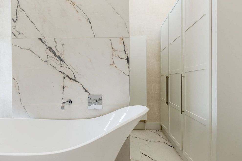 Photo of a mid-sized contemporary master bathroom in Other with flat-panel cabinets, white cabinets, a freestanding tub, an open shower, beige tile, stone slab, beige walls and marble floors.