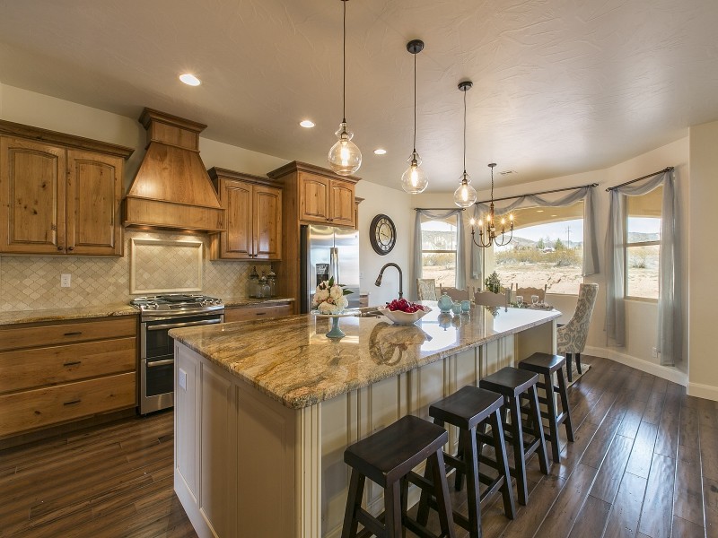 Eclectic single-wall open plan kitchen in Salt Lake City with an undermount sink, medium wood cabinets, granite benchtops, beige splashback, mosaic tile splashback and stainless steel appliances.