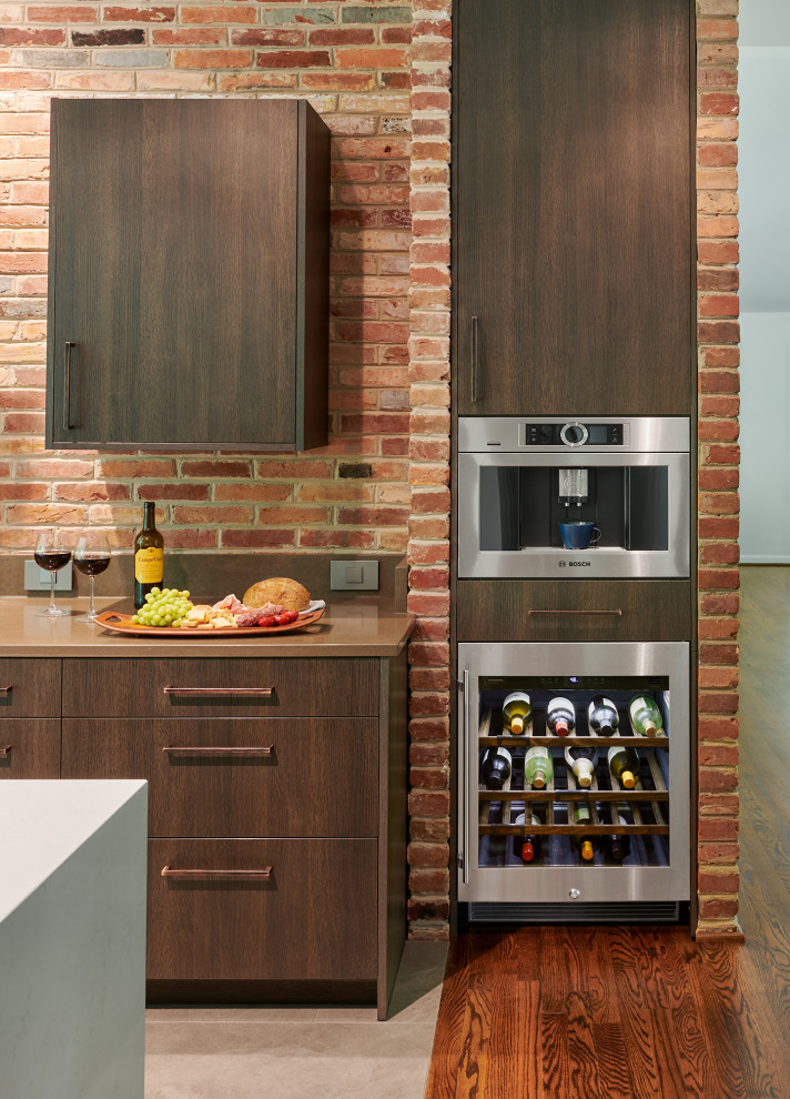 Immagine di una cucina moderna di medie dimensioni con ante lisce, ante marroni, paraspruzzi marrone, paraspruzzi in mattoni, elettrodomestici in acciaio inossidabile, pavimento grigio e top marrone