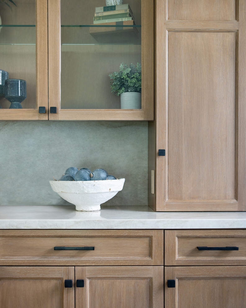 Mid-sized mediterranean galley home bar in Los Angeles with recessed-panel cabinets, medium wood cabinets, marble benchtops, blue splashback, marble splashback, terra-cotta floors, beige floor and white benchtop.