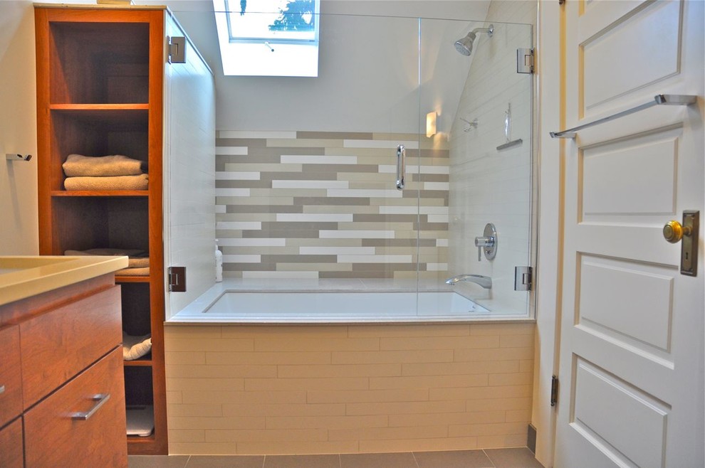 Design ideas for a mid-sized contemporary master bathroom in Portland with flat-panel cabinets, medium wood cabinets, an undermount tub, a shower/bathtub combo, beige tile, white tile, porcelain tile, white walls, ceramic floors, an undermount sink, grey floor and a hinged shower door.