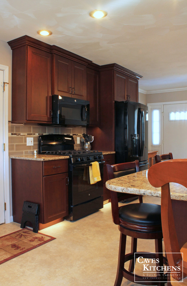 Inspiration for a mid-sized transitional l-shaped vinyl floor eat-in kitchen remodel with an undermount sink, flat-panel cabinets, dark wood cabinets, quartz countertops, beige backsplash, ceramic backsplash, black appliances and an island