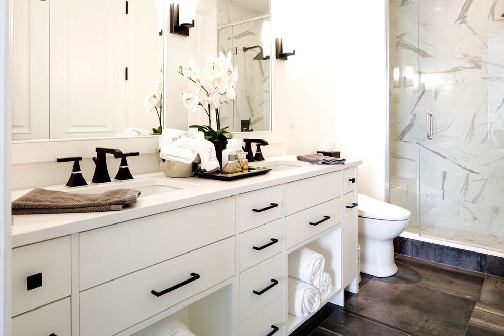 Mid-sized transitional master white tile and stone slab porcelain tile and gray floor alcove shower photo with flat-panel cabinets, white cabinets, a two-piece toilet, white walls, an undermount sink, quartz countertops and a hinged shower door