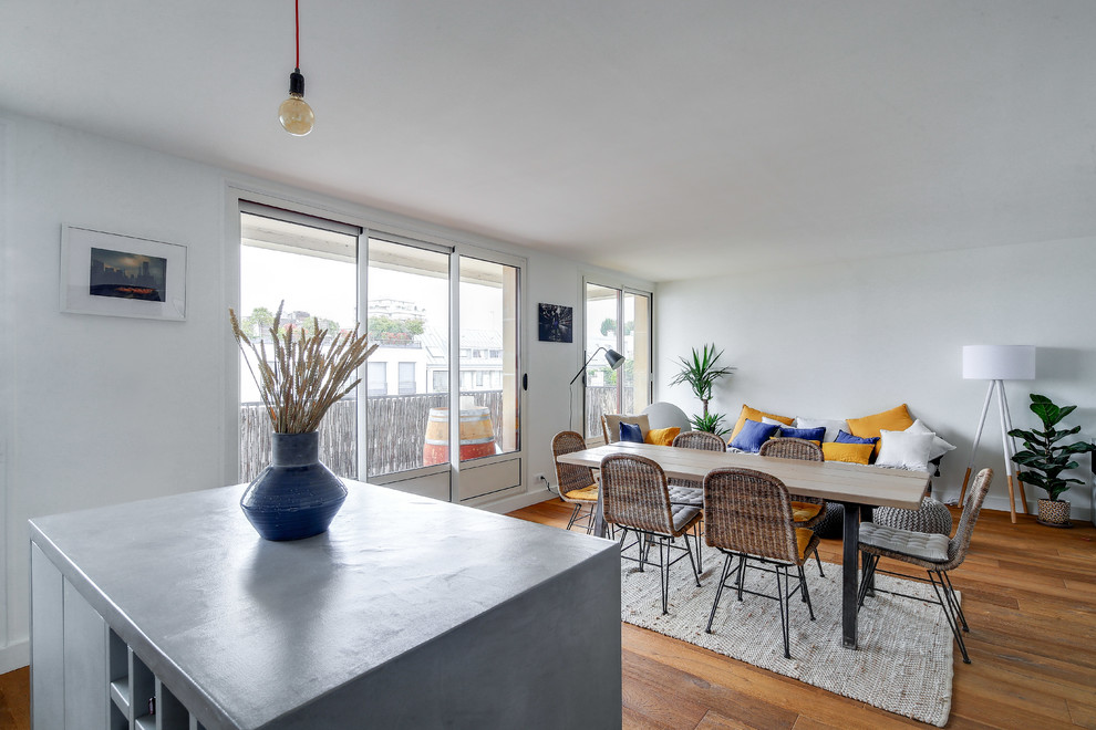 Inspiration pour une grande salle à manger ouverte sur le salon design avec un mur blanc, un sol en bois brun, aucune cheminée et un sol marron.