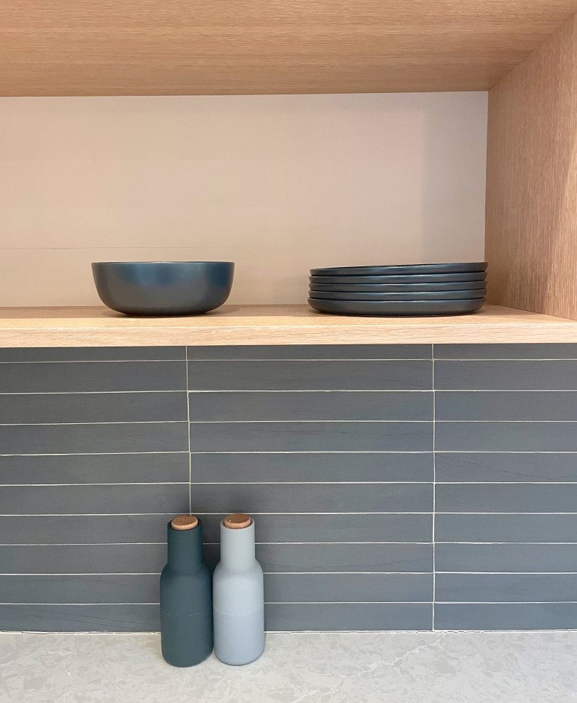 Offene Moderne Küche in L-Form mit hellen Holzschränken, Küchenrückwand in Blau und grauer Arbeitsplatte in Los Angeles
