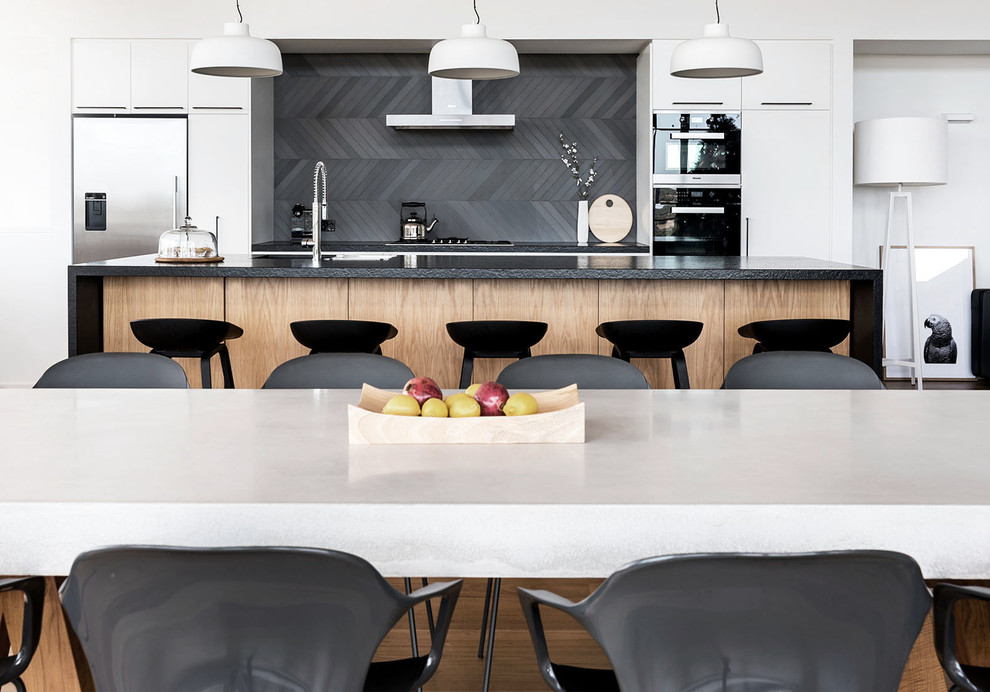 This is an example of a mid-sized modern single-wall eat-in kitchen in Perth with a double-bowl sink, white cabinets, granite benchtops, blue splashback, ceramic splashback, black appliances, light hardwood floors and with island.