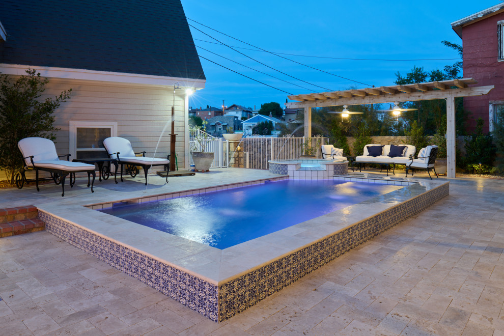 Diseño de piscina con fuente tradicional pequeña rectangular en patio trasero con adoquines de piedra natural