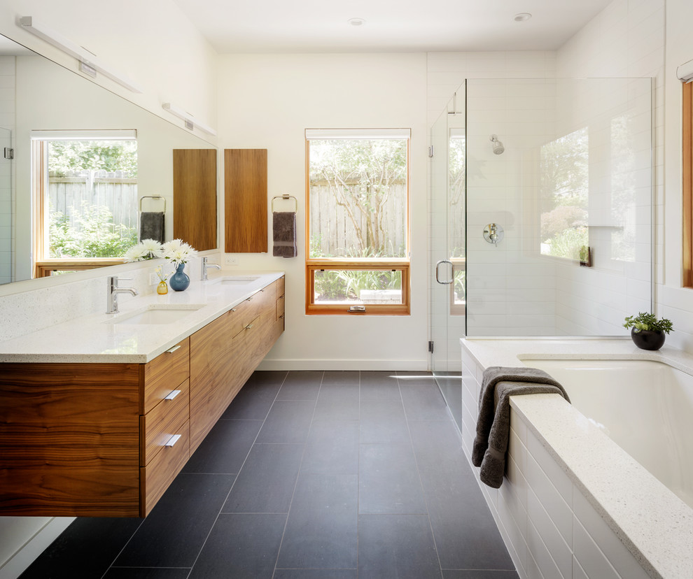 Photo of a large contemporary master bathroom in Portland with a hinged shower door, flat-panel cabinets, an undermount tub, white tile, white walls, an undermount sink, grey floor, white benchtops, a corner shower, ceramic tile, porcelain floors and engineered quartz benchtops.