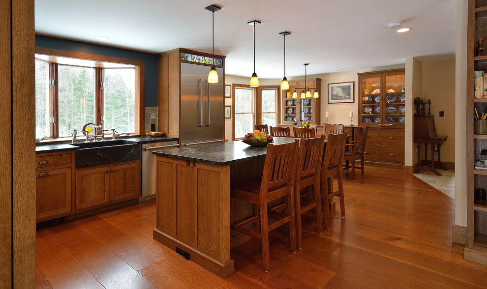 Design ideas for a mid-sized arts and crafts l-shaped eat-in kitchen in Portland Maine with a farmhouse sink, shaker cabinets, medium wood cabinets, stainless steel appliances and medium hardwood floors.