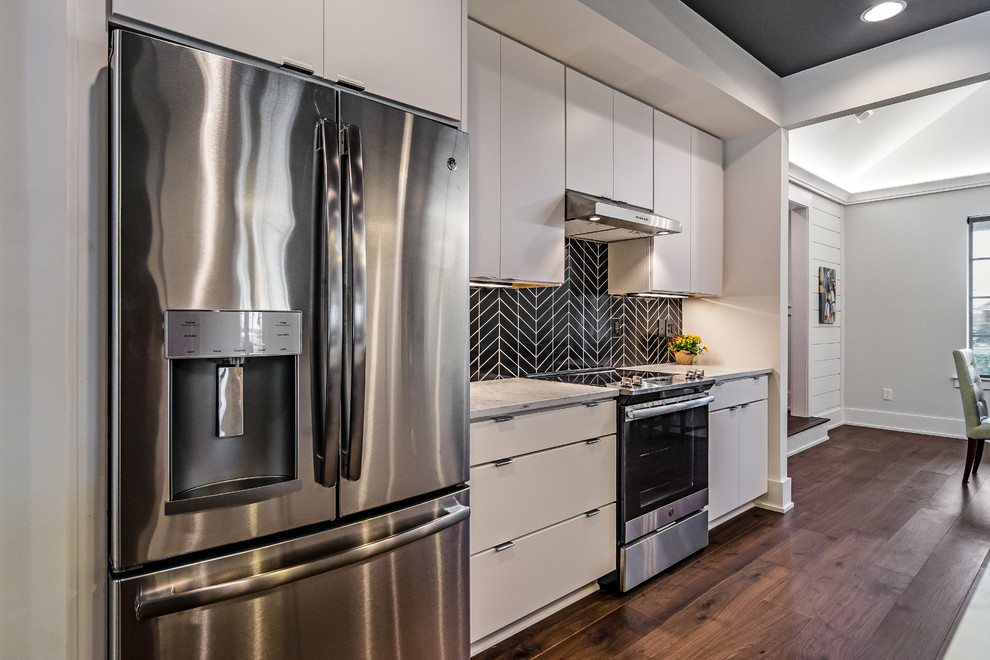 Photo of a large contemporary galley open plan kitchen in Other with an undermount sink, flat-panel cabinets, white cabinets, marble benchtops, black splashback, ceramic splashback, stainless steel appliances, dark hardwood floors, with island and brown floor.