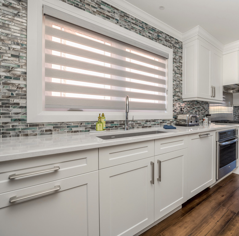 Inspiration for a large transitional galley dark wood floor and brown floor eat-in kitchen remodel with an undermount sink, shaker cabinets, white cabinets, quartz countertops, multicolored backsplash, mosaic tile backsplash, stainless steel appliances, an island and multicolored countertops