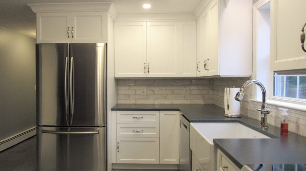 Mid-sized transitional u-shaped porcelain tile and gray floor eat-in kitchen photo in Boston with a farmhouse sink, recessed-panel cabinets, white cabinets, quartz countertops, gray backsplash, ceramic backsplash, stainless steel appliances, a peninsula and gray countertops