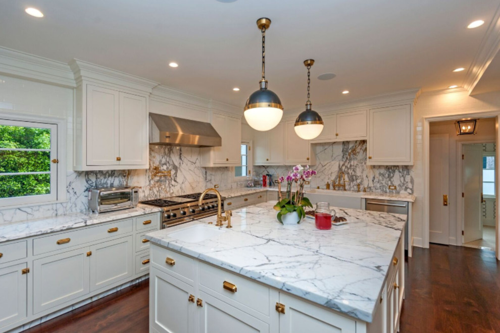 This is an example of a mid-sized transitional u-shaped separate kitchen in Los Angeles with a farmhouse sink, shaker cabinets, blue cabinets, marble benchtops, white splashback, marble splashback, stainless steel appliances, dark hardwood floors and with island.