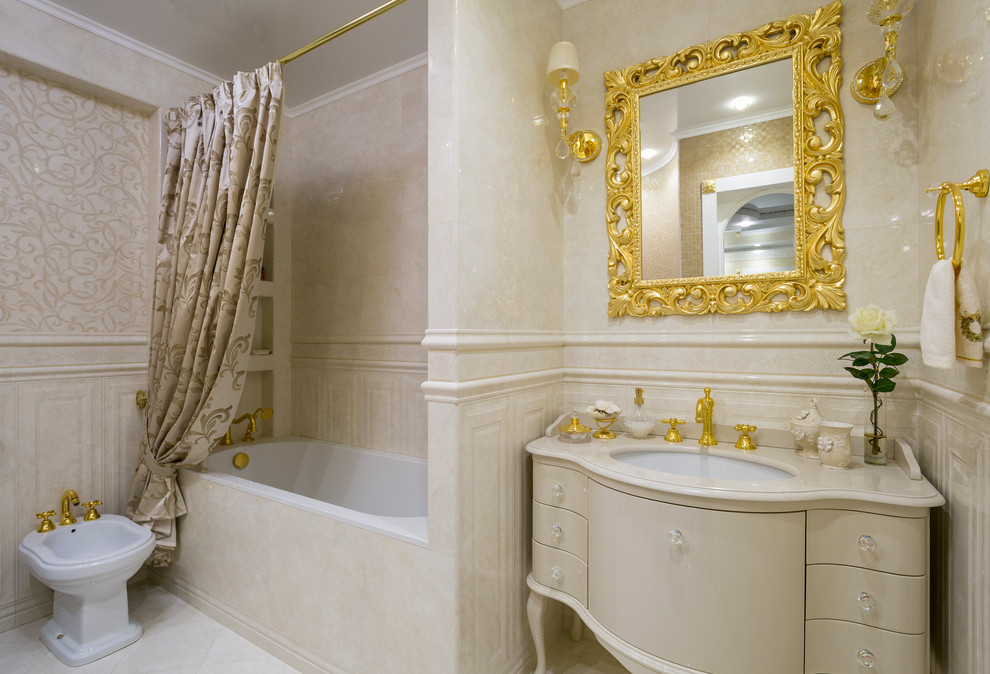 Inspiration for a mid-sized traditional master bathroom in Moscow with beige cabinets, an alcove tub, a shower/bathtub combo, beige tile, ceramic tile, ceramic floors, an undermount sink, marble benchtops, beige floor, a shower curtain, flat-panel cabinets, a bidet and beige benchtops.