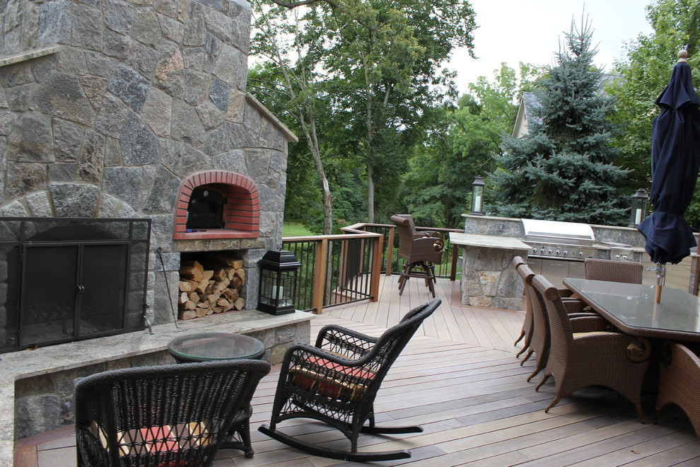 Example of a large transitional backyard deck design in Bridgeport with a fire pit and no cover
