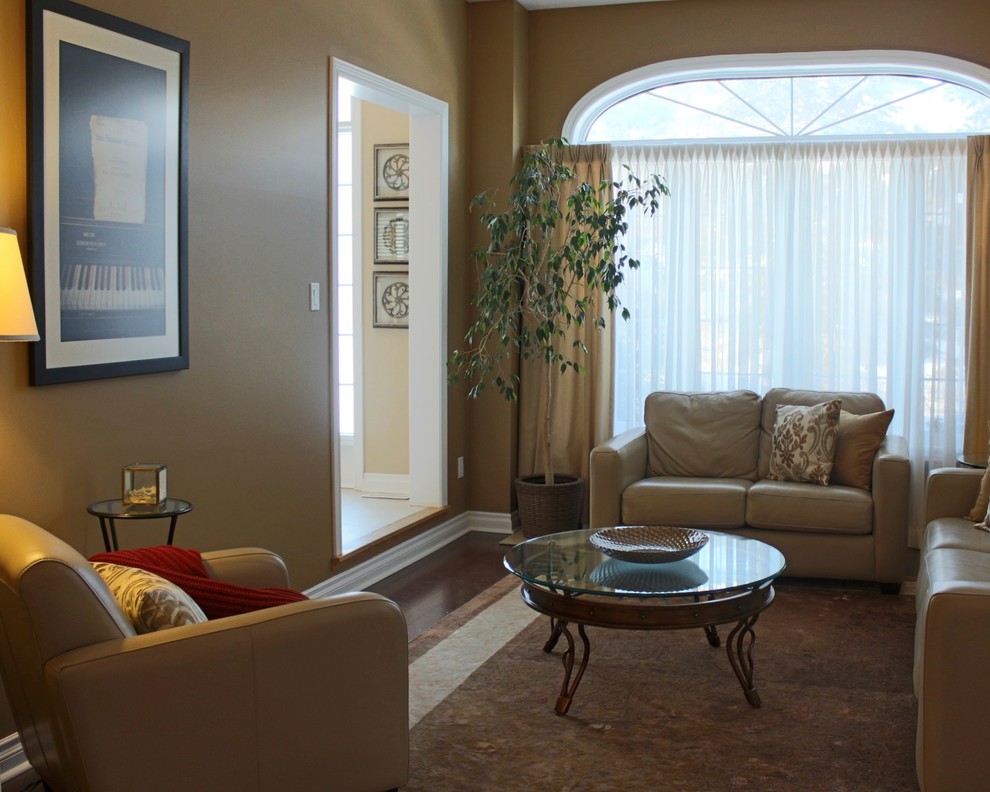 This is an example of a mid-sized traditional enclosed living room in Toronto with beige walls and dark hardwood floors.