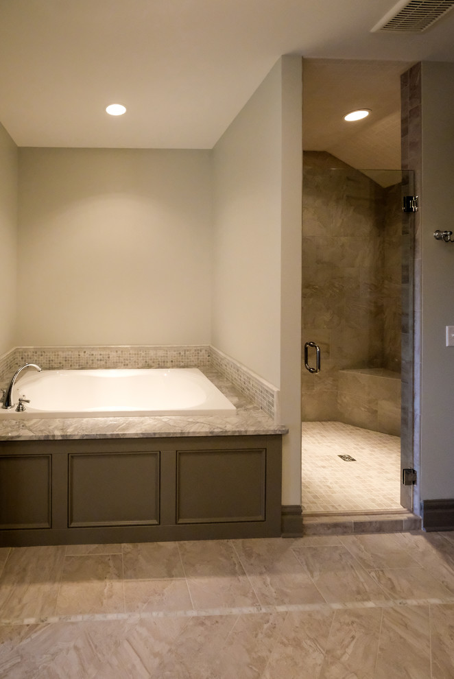 Photo of a large transitional master bathroom in Other with recessed-panel cabinets, a corner tub, beige tile, beige walls, granite benchtops, beige floor, a hinged shower door, grey cabinets and an alcove shower.
