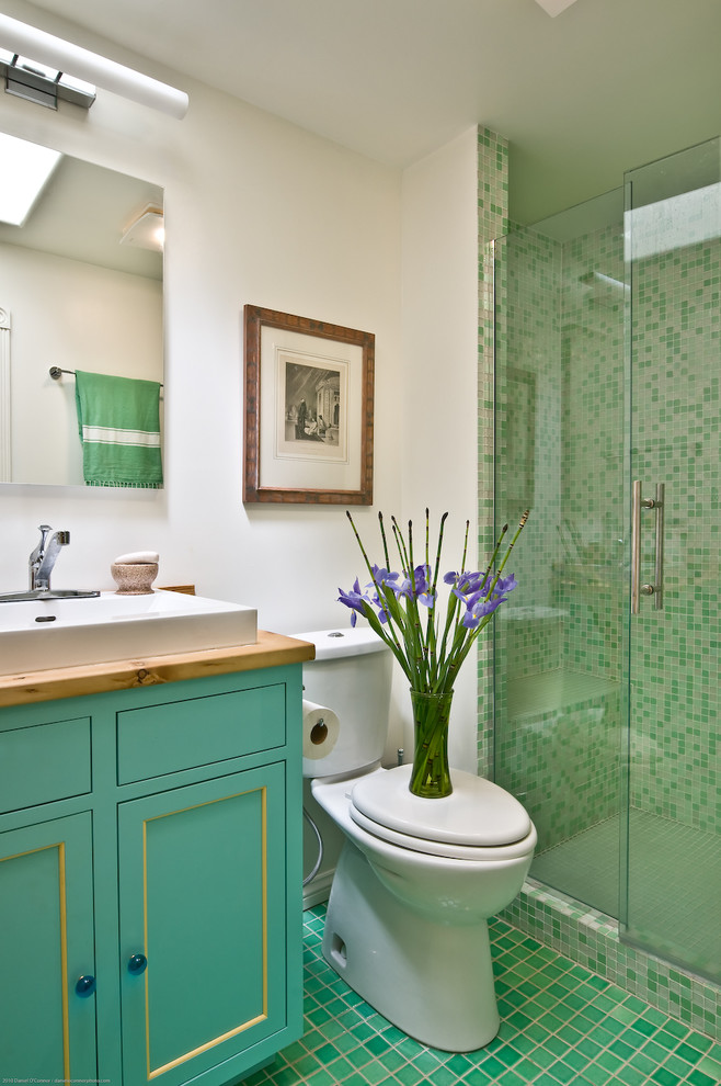 Inspiration for a mid-sized country 3/4 bathroom in Denver with beaded inset cabinets, turquoise cabinets, an alcove shower, a two-piece toilet, green tile, porcelain tile, white walls, porcelain floors, a vessel sink, wood benchtops, green floor and a hinged shower door.