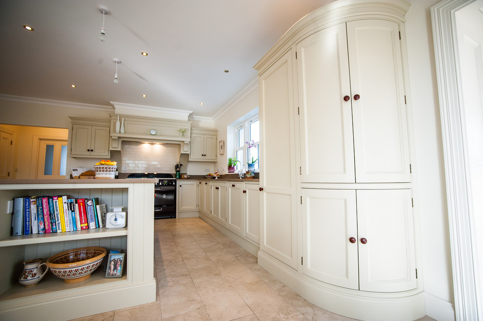 This is an example of a large traditional l-shaped eat-in kitchen in Other with an undermount sink, recessed-panel cabinets, beige cabinets, quartz benchtops, beige splashback, ceramic splashback, black appliances, ceramic floors and with island.