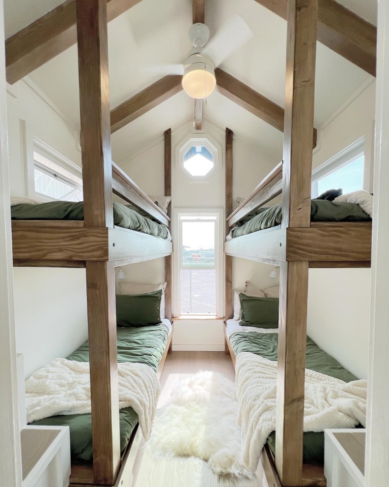 Immagine di una piccola cameretta per bambini da 4 a 10 anni country con pareti bianche, pavimento in vinile, pavimento beige, travi a vista e pareti in legno