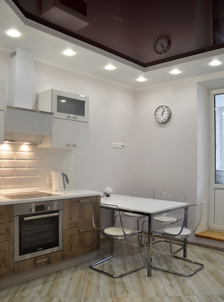 This is an example of a mid-sized contemporary l-shaped eat-in kitchen in Moscow with recessed-panel cabinets, solid surface benchtops, white splashback, ceramic splashback, stainless steel appliances, ceramic floors, no island, beige floor and dark wood cabinets.