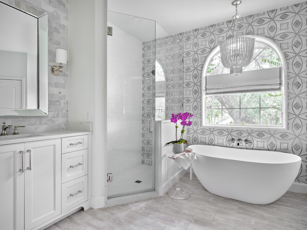 Example of a mid-sized transitional master marble tile, gray tile and white tile porcelain tile and gray floor bathroom design in Austin with shaker cabinets, white cabinets, white walls, an undermount sink, quartz countertops, a hinged shower door, white countertops and a built-in vanity