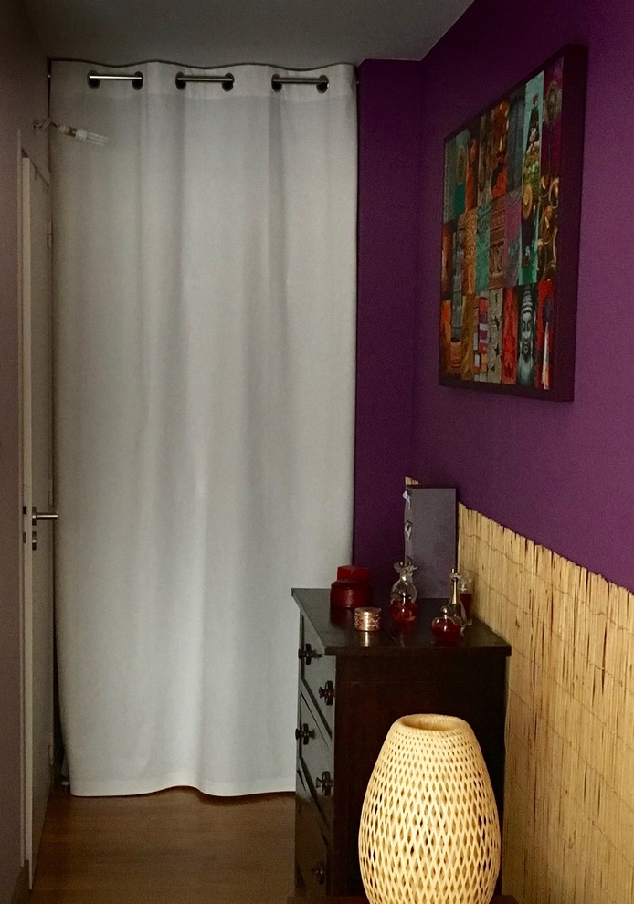 Mid-sized tropical master bedroom in Nantes with purple walls, dark hardwood floors and brown floor.